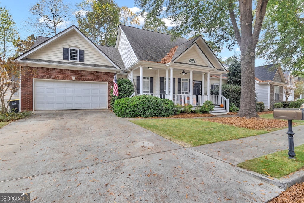 view of front of house with a garage, a front yard, and a porch