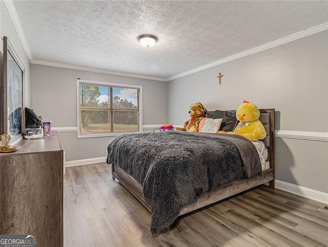 bedroom featuring hardwood / wood-style floors, a textured ceiling, and crown molding