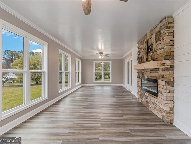 unfurnished living room featuring ornamental molding, a fireplace, hardwood / wood-style flooring, and ceiling fan