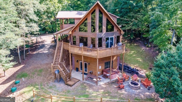 back of house with a deck, a fire pit, and a patio area