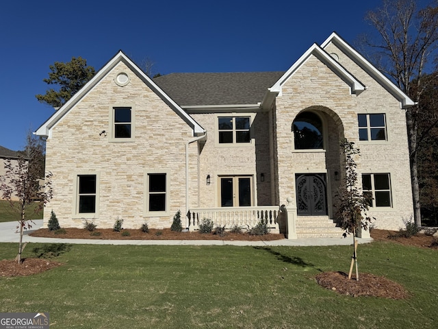 view of front of property featuring a front yard and french doors