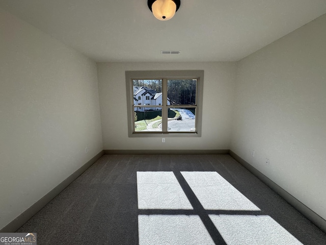 spare room featuring dark carpet