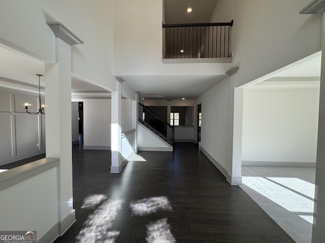 foyer featuring dark wood-type flooring and a chandelier