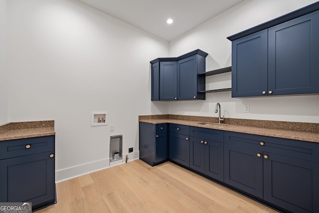 kitchen with light hardwood / wood-style floors, sink, and blue cabinets