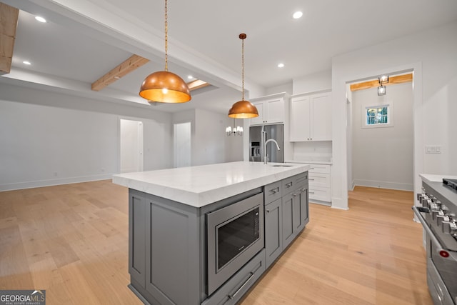 kitchen featuring gray cabinetry, light hardwood / wood-style floors, white cabinets, high end appliances, and a kitchen island with sink