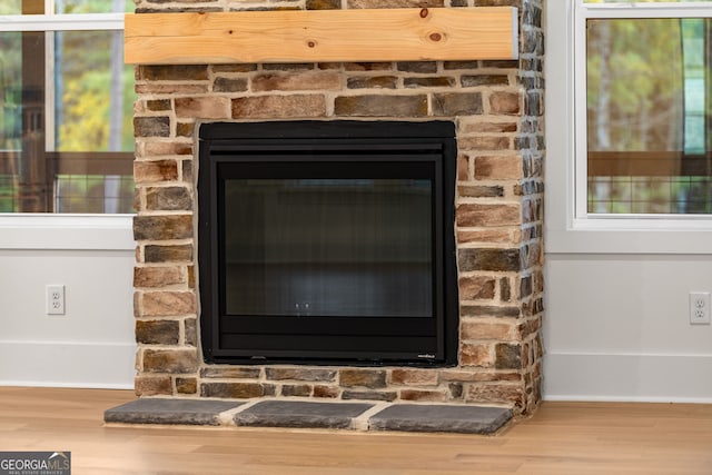 room details with a stone fireplace and hardwood / wood-style flooring