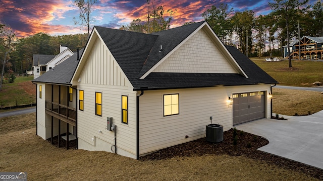 property exterior at dusk with a lawn and central AC unit