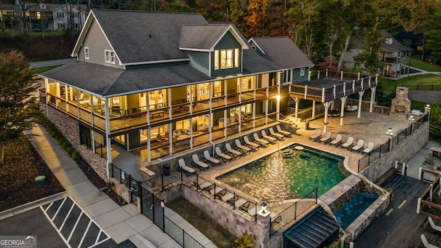 back of house featuring a fenced in pool, a patio area, and a balcony