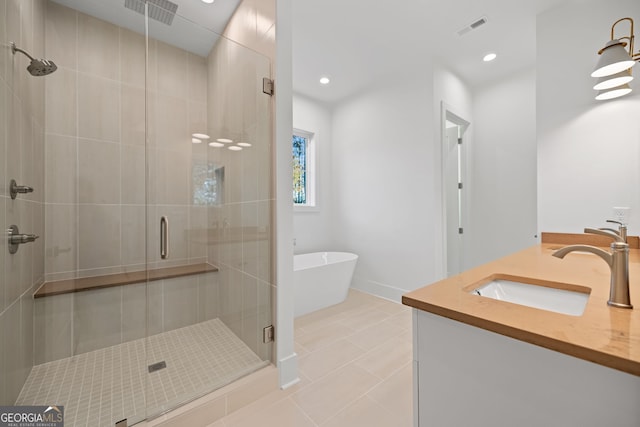 bathroom featuring independent shower and bath, vanity, and tile patterned flooring