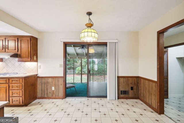 interior space featuring wooden walls and ceiling fan