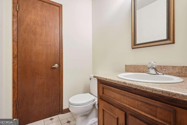 bathroom with tile patterned flooring, vanity, and toilet