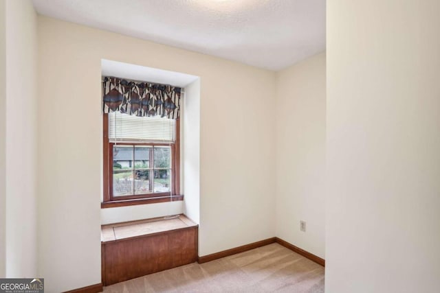 carpeted empty room featuring a textured ceiling