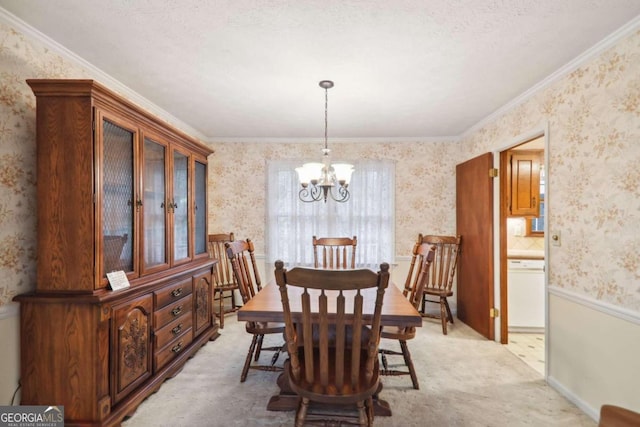 carpeted dining space with a textured ceiling, crown molding, and an inviting chandelier