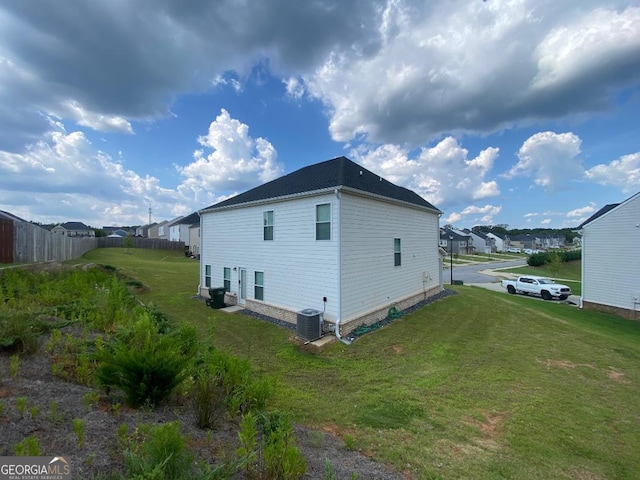 view of home's exterior with central AC unit and a yard