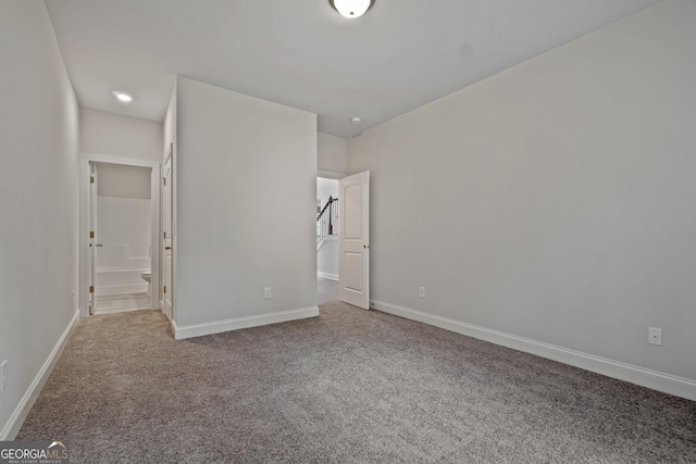 unfurnished bedroom featuring carpet flooring and ensuite bathroom