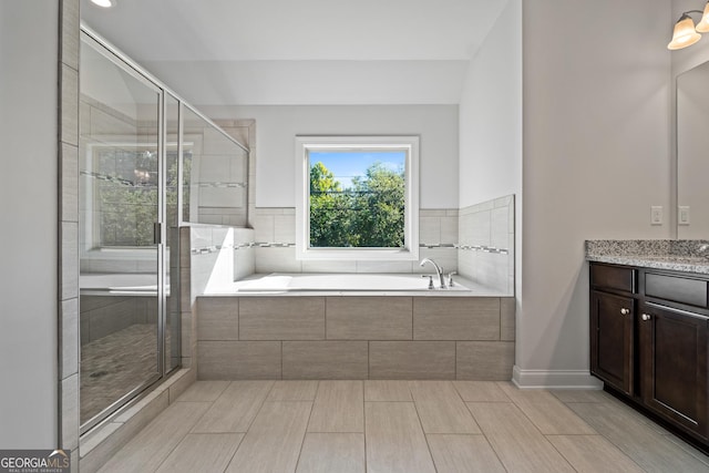 bathroom with vanity and independent shower and bath