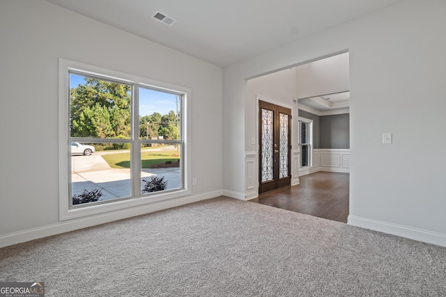 carpeted spare room featuring crown molding and french doors