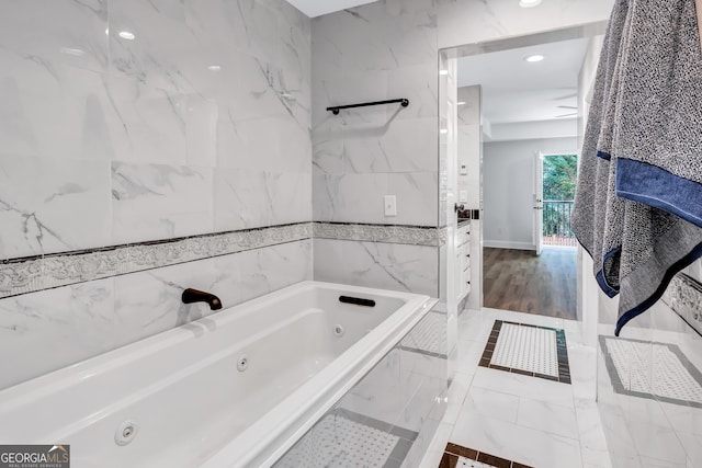 bathroom featuring hardwood / wood-style floors and tiled tub