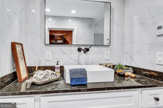 bathroom featuring vanity and tile walls