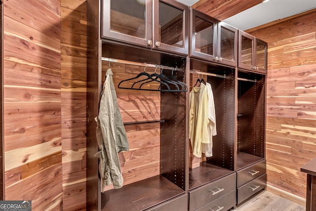 mudroom with light hardwood / wood-style flooring and wooden walls