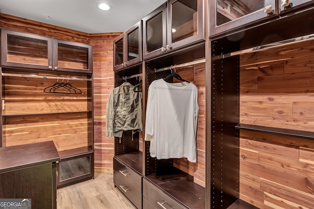 mudroom with light hardwood / wood-style floors and wooden walls