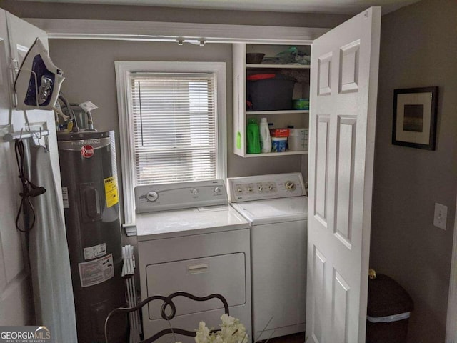 clothes washing area featuring electric water heater and washer and dryer