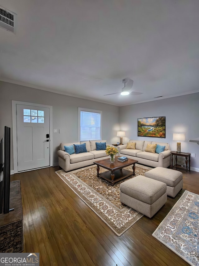 living room with a wealth of natural light, dark hardwood / wood-style flooring, ceiling fan, and ornamental molding