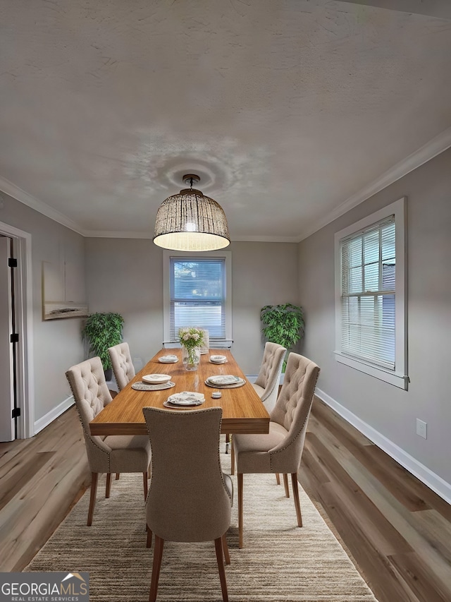 dining space featuring crown molding and hardwood / wood-style floors