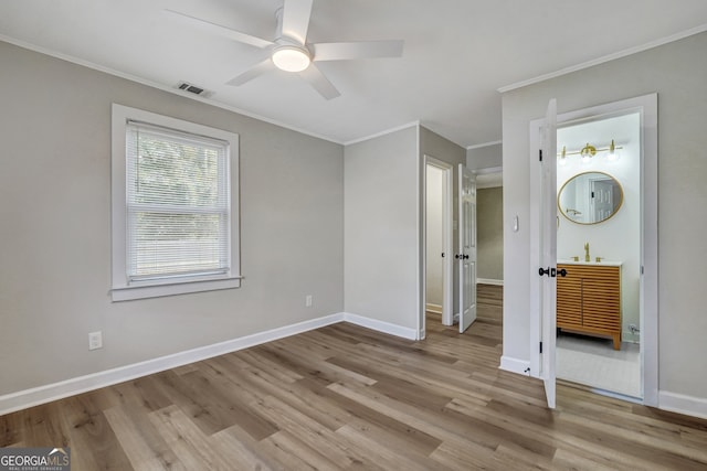 unfurnished bedroom with connected bathroom, ceiling fan, ornamental molding, and light wood-type flooring