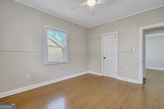 empty room with ceiling fan, hardwood / wood-style floors, and ornamental molding