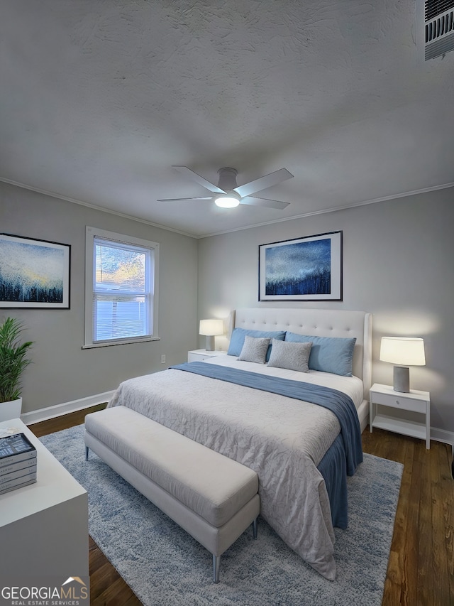 bedroom with a textured ceiling, dark hardwood / wood-style floors, ceiling fan, and ornamental molding