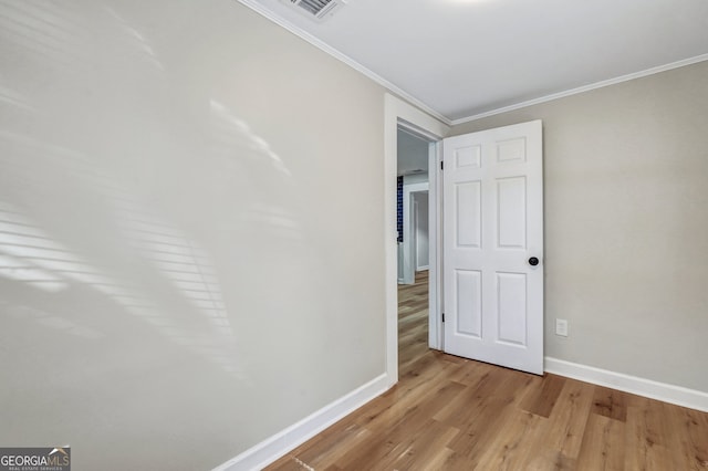 unfurnished bedroom with crown molding and light hardwood / wood-style floors