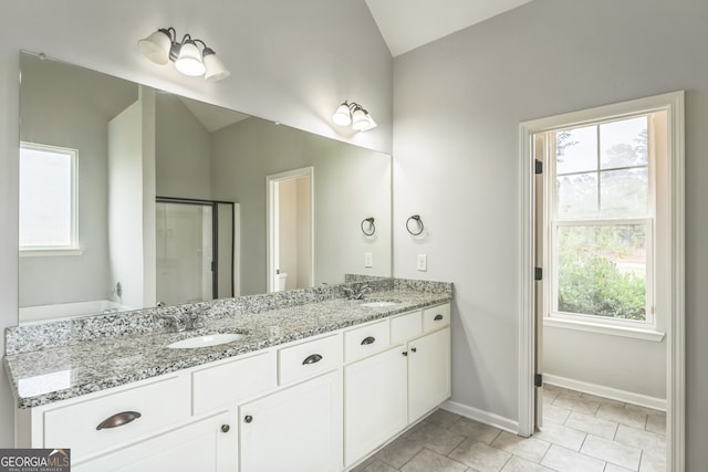 bathroom with tile patterned flooring, vanity, lofted ceiling, and a shower with shower door