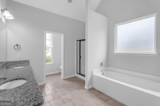 full bathroom featuring shower with separate bathtub, vanity, vaulted ceiling, tile patterned flooring, and toilet