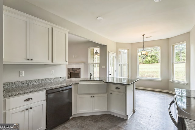 kitchen featuring white cabinetry, kitchen peninsula, light stone countertops, range, and black dishwasher