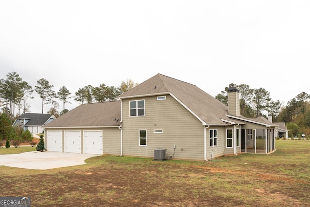 back of house featuring a sunroom, a garage, central AC, and a yard