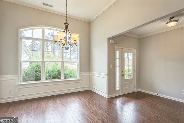 interior space with dark hardwood / wood-style flooring, a wealth of natural light, a chandelier, and ornamental molding