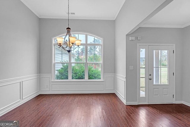 entryway with dark hardwood / wood-style flooring, a chandelier, and ornamental molding