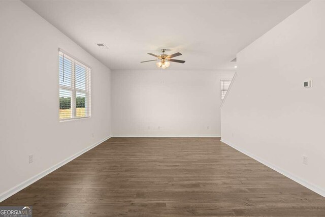 unfurnished room with ceiling fan and dark hardwood / wood-style flooring