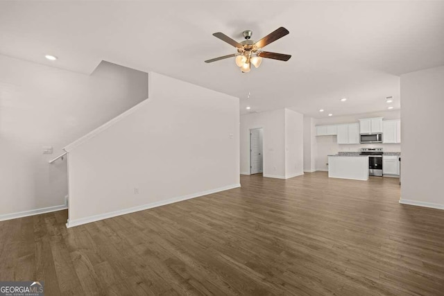 unfurnished living room with ceiling fan and dark wood-type flooring