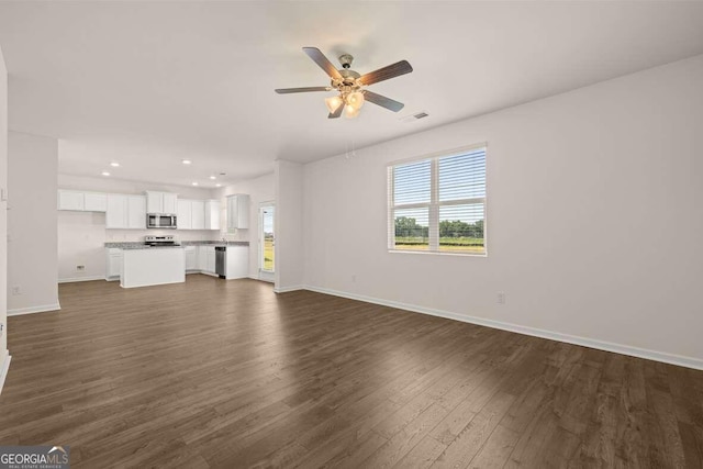 unfurnished living room featuring ceiling fan and dark hardwood / wood-style floors