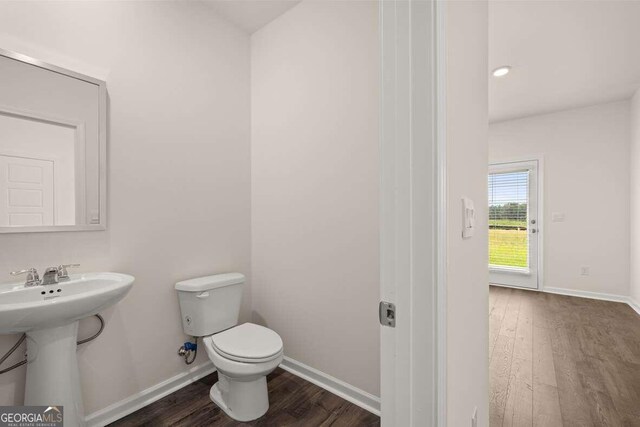 bathroom with hardwood / wood-style floors, toilet, and sink