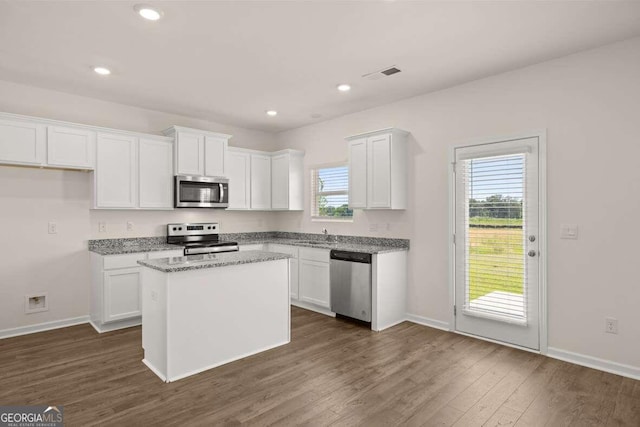 kitchen with white cabinetry, plenty of natural light, a kitchen island, and appliances with stainless steel finishes