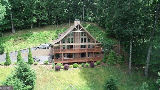 rear view of house with a lawn and a deck