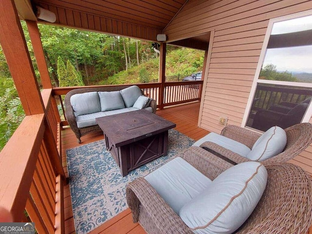 wooden terrace with an outdoor living space