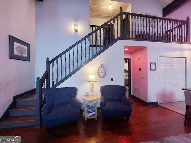 living room featuring a high ceiling, wood-type flooring, and beam ceiling