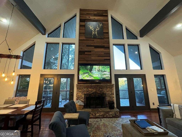 living room featuring high vaulted ceiling, beamed ceiling, and plenty of natural light