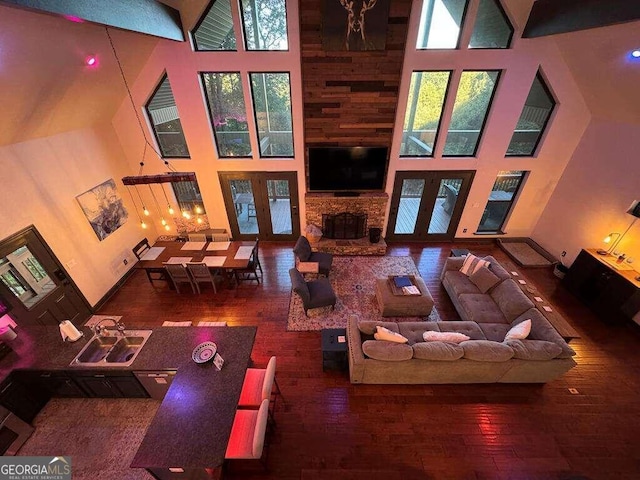 living room featuring a wealth of natural light, wood-type flooring, and a high ceiling