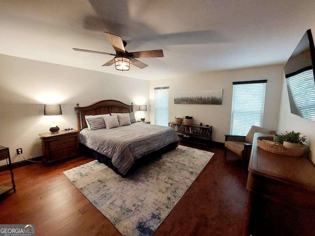 bedroom with dark hardwood / wood-style flooring and ceiling fan