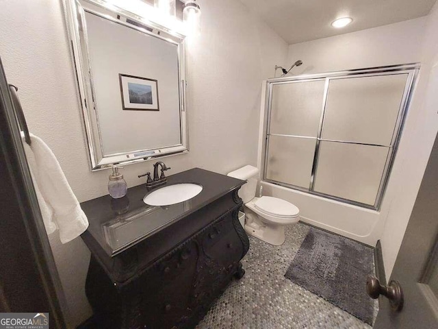 full bathroom with vanity, combined bath / shower with glass door, and toilet